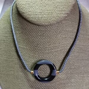 Goldtone gray black round donut pendant on gray cord necklace